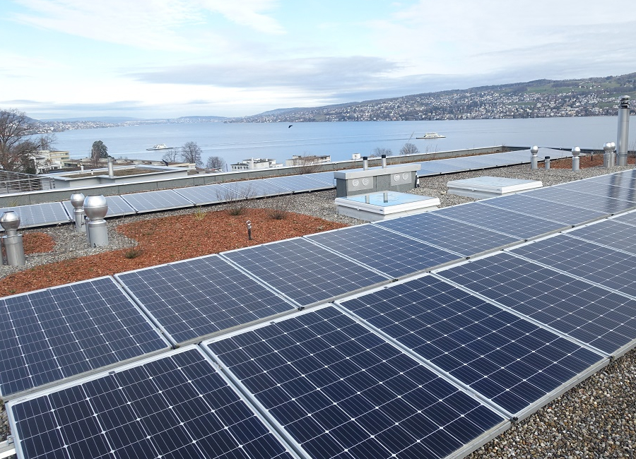 Mit Photovoltaik belegtes Flachdach, Im Hintergrund der Zürichsee.